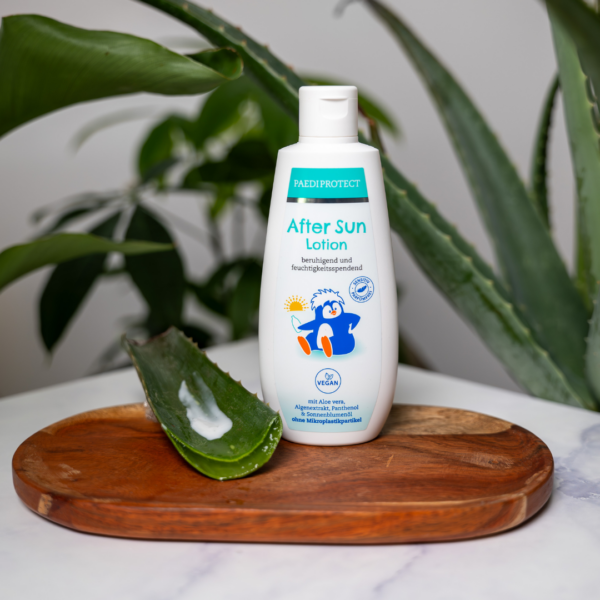 a bottle of lotion on a wood tray with aloe vera