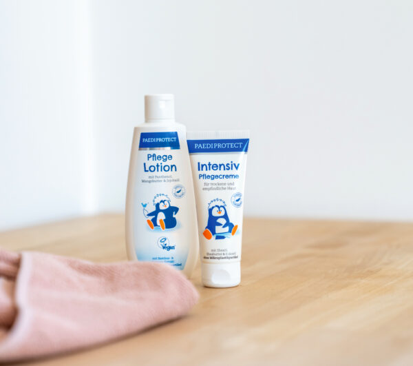 PAEDIPROTECT Pflegelotion + Intensiv Pflegecreme auf ein Holz Tisch