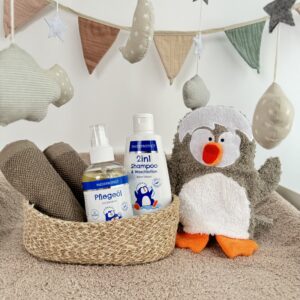 PAEDIPROTECT 2in1 Shampoo & Waschlotion, Pflegeöl und Waschlappen auf einem Wickeltisch