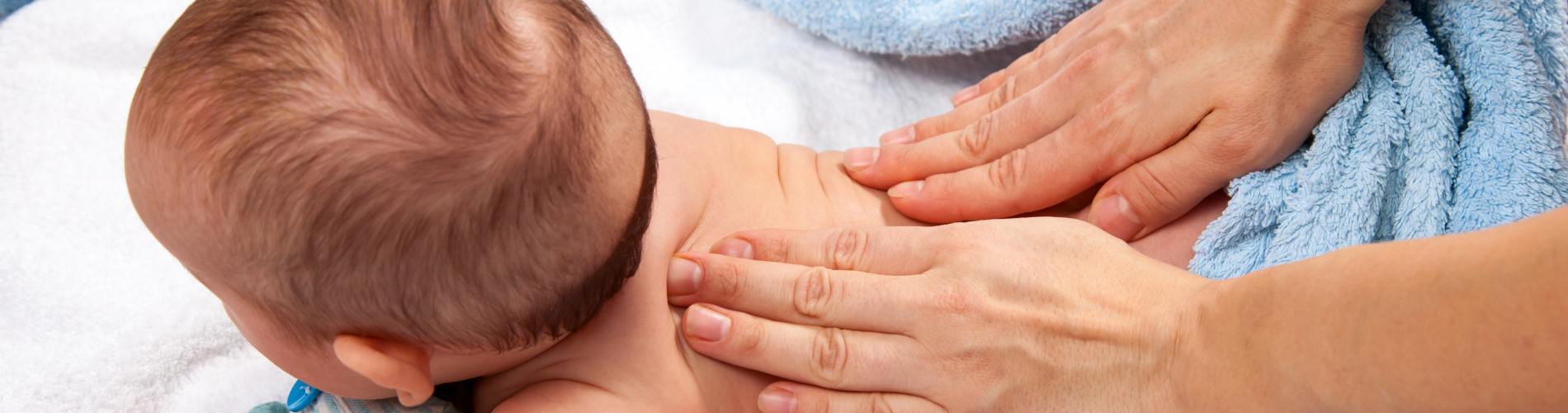 a close-up of hands massaging a baby's back